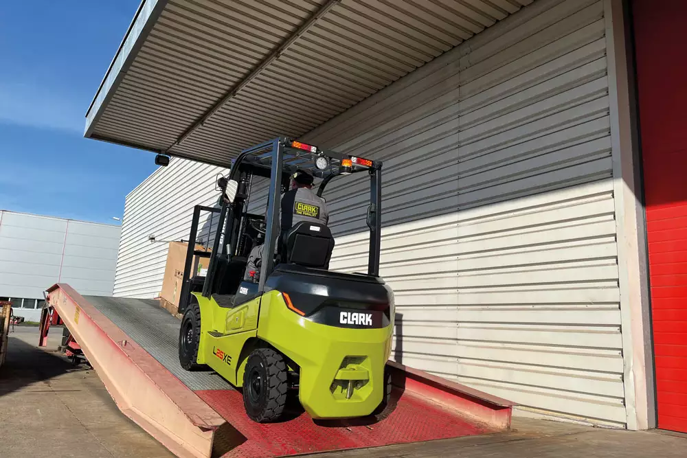 Clark LXE pneu pneumatico em patio externo — operacao mista galpao e rampa de doca